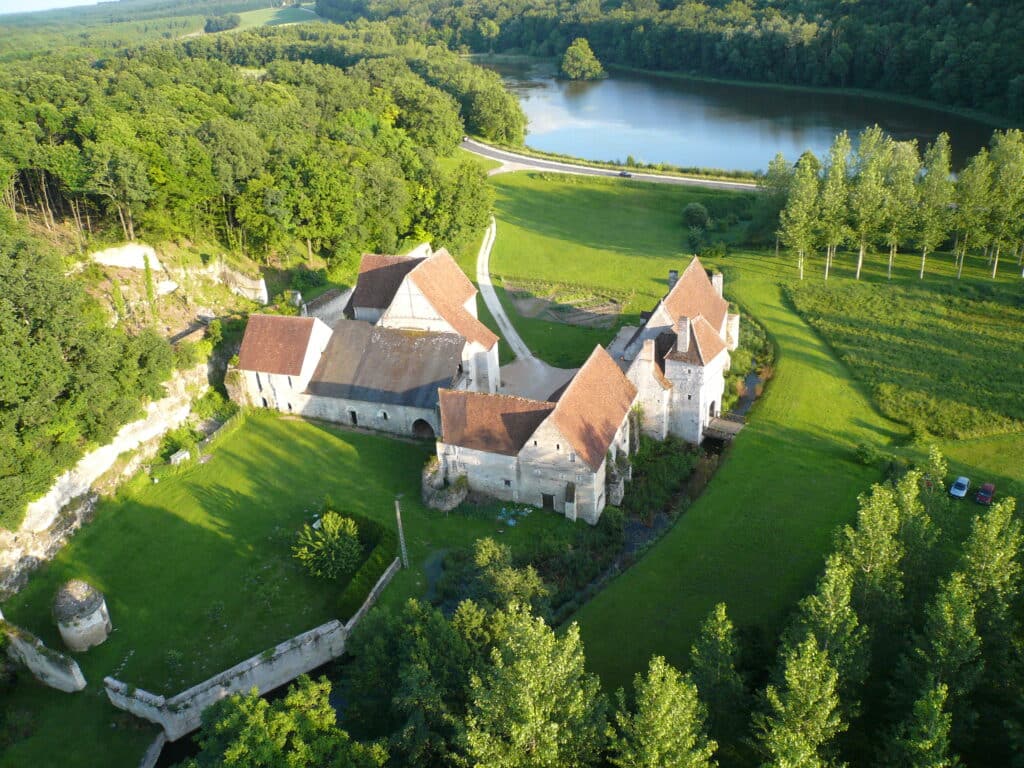 Vue aérienne du château-monastère de la Corroirie, niché entre forêt et étangs, avec accès direct par la route de Loches à Montrésor (RD 760), à 4 km de Montrésor et 12 km de Loches
